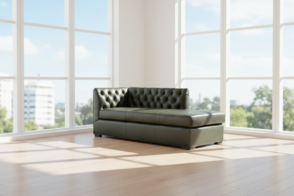 Green tufted leather daybed in bright open loft on light hardwood floor with large windows