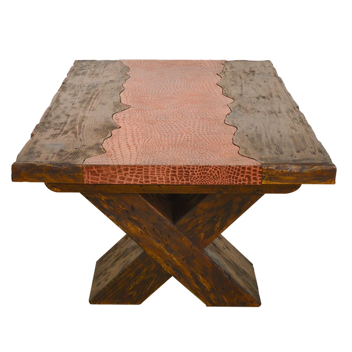 A rustic wooden end table with a thick, square, live-edge top featuring a central coppery-pink alligator-patterned inlay, supported by a dark brown X-shaped wooden base.