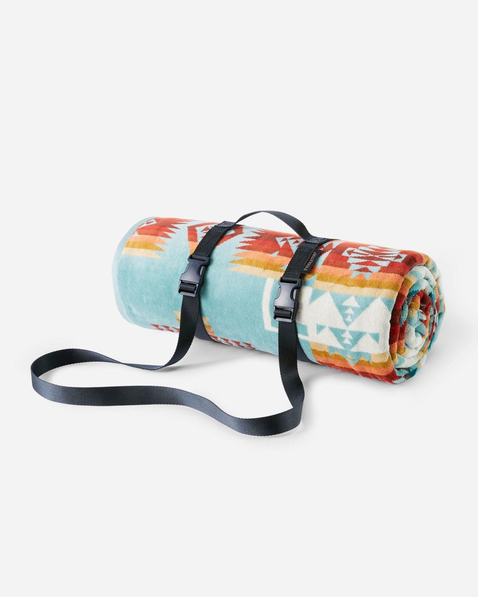 Pendleton Chief Joseph beach blanket rolled for travel with convenient carrying strap.