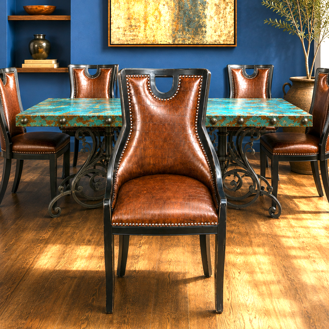 A dining room scene showing a brown leather high-back chair in the foreground, with matching brown leather and turquoise table chairs around a rectangular table with a turquoise top and black wrought-iron legs. Blue wall, wood floor, shelving, and wall art are visible.