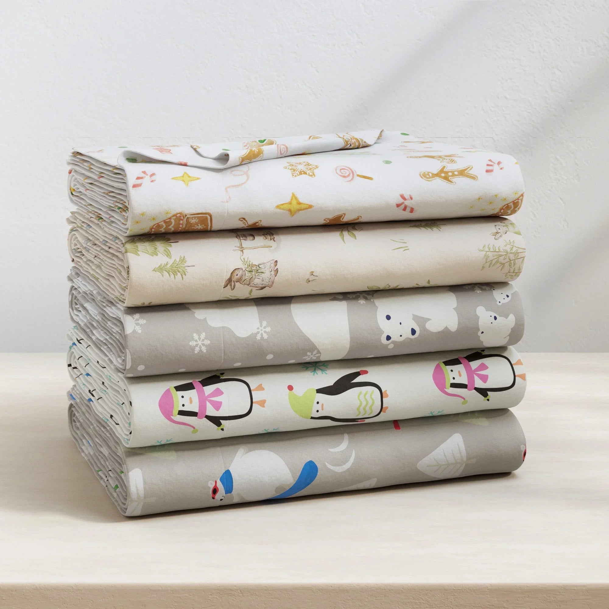 Stack of folded fabric sheets with animal patterns on a light surface.