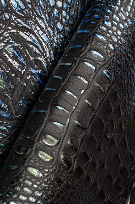 Close-up of black croc leather with blue and green metallic tones