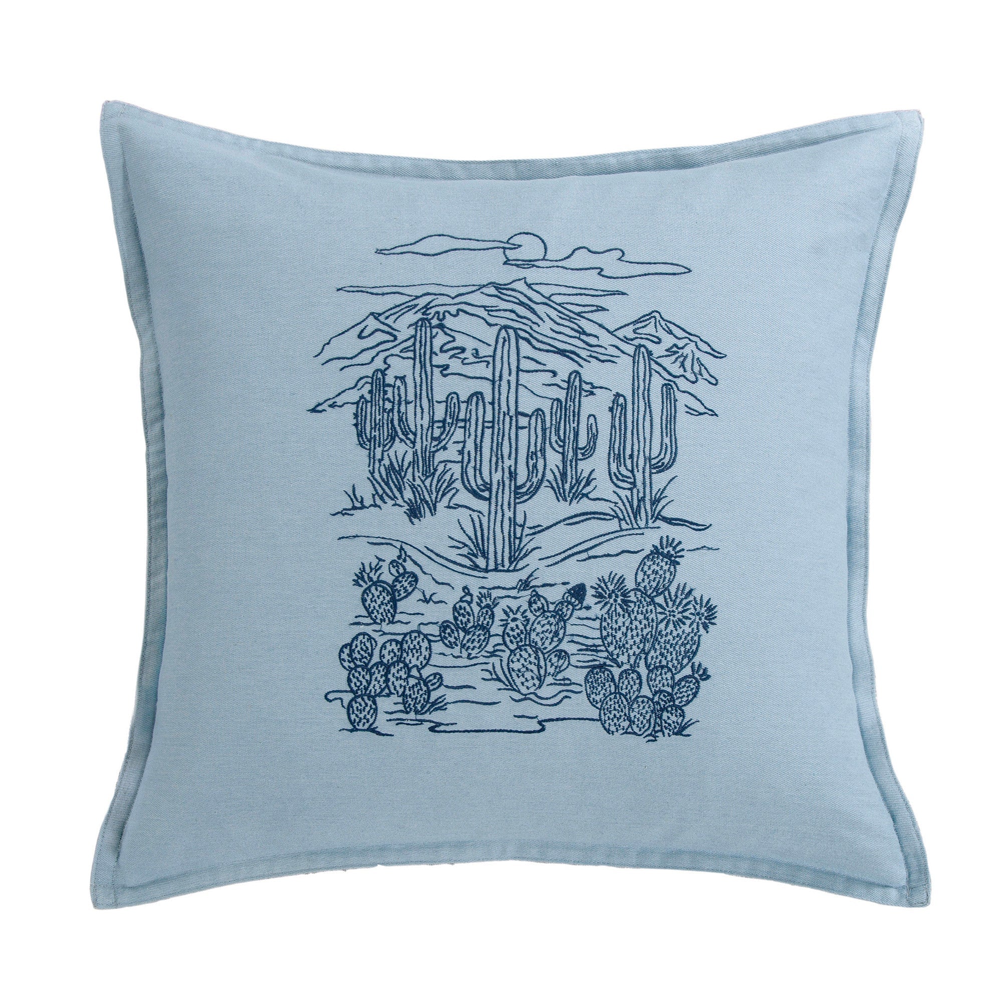 Blue pillow with desert landscape design featuring cacti and mountains on a white background