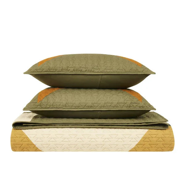 Quilt and pillows with geometric pattern on a white background