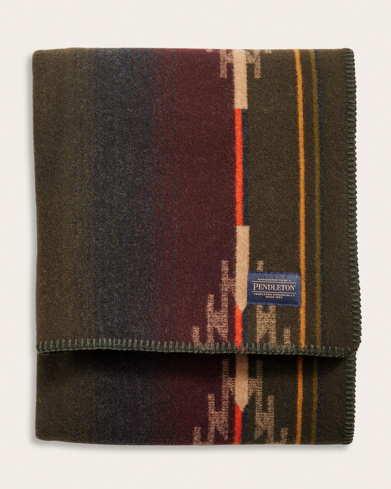 Folded Pendleton blanket with colorful pattern on a white background