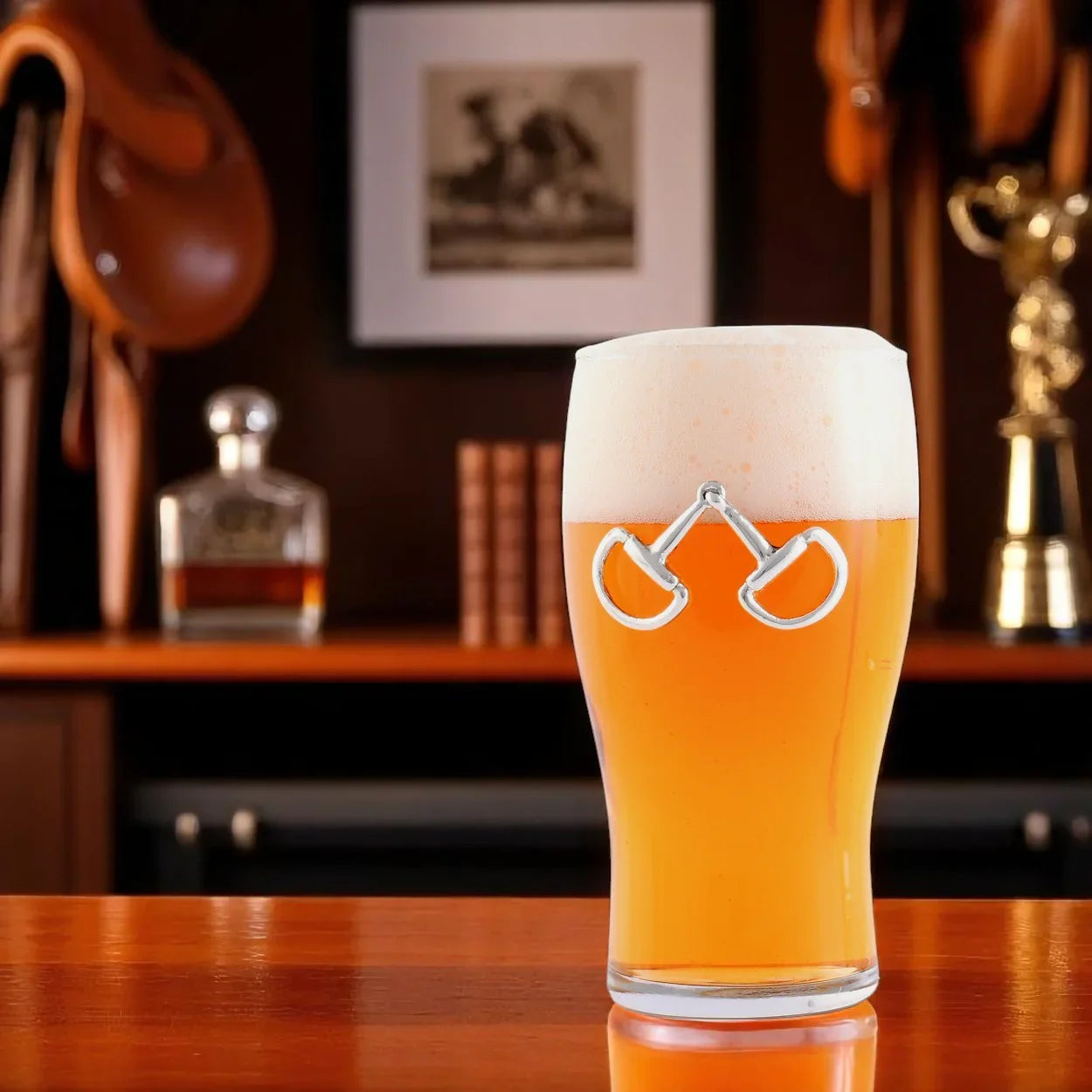 Glass of beer with a decorative snaffle bit on a wooden surface, with a blurred background