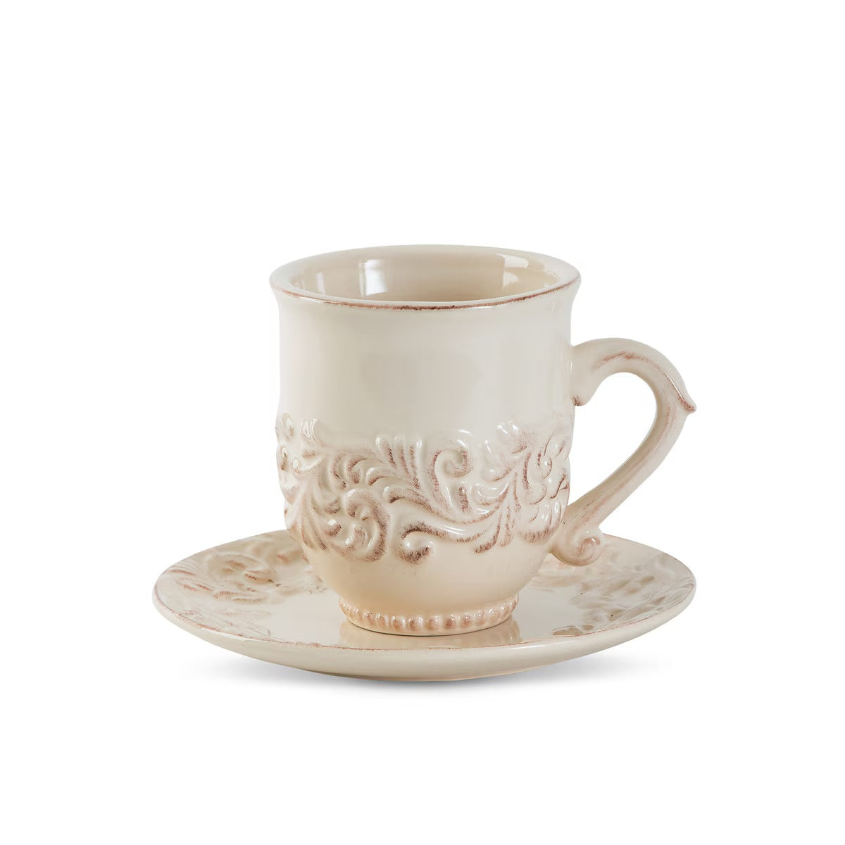 Cream-colored ceramic cup and saucer with intricate patterns on a white background