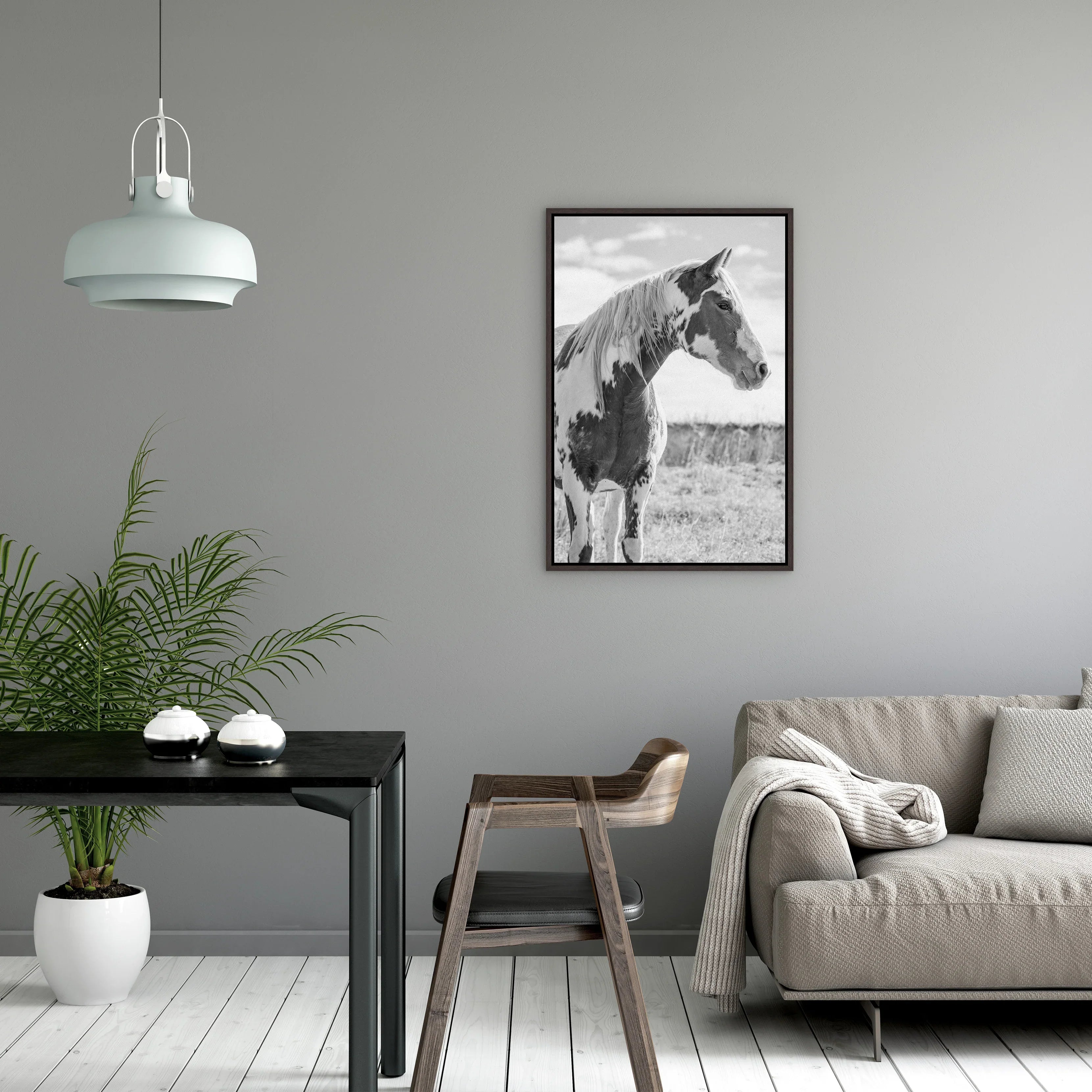 Modern living room with a horse print on the wall, gray sofa, and wooden chair - Your Western Decor