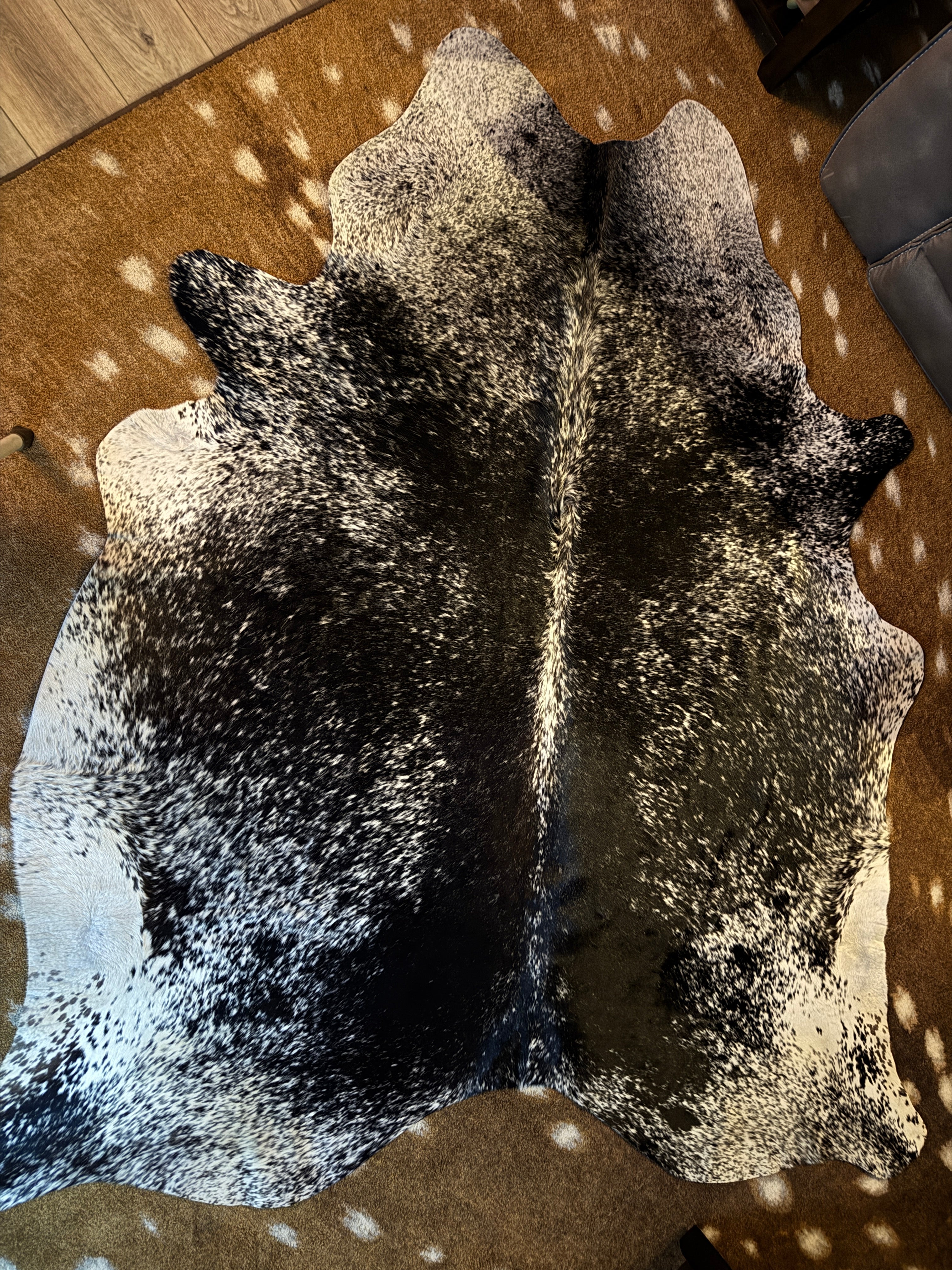 Black and white peppered cowhide rug over Axis deer hide print rug - Your Western Decor