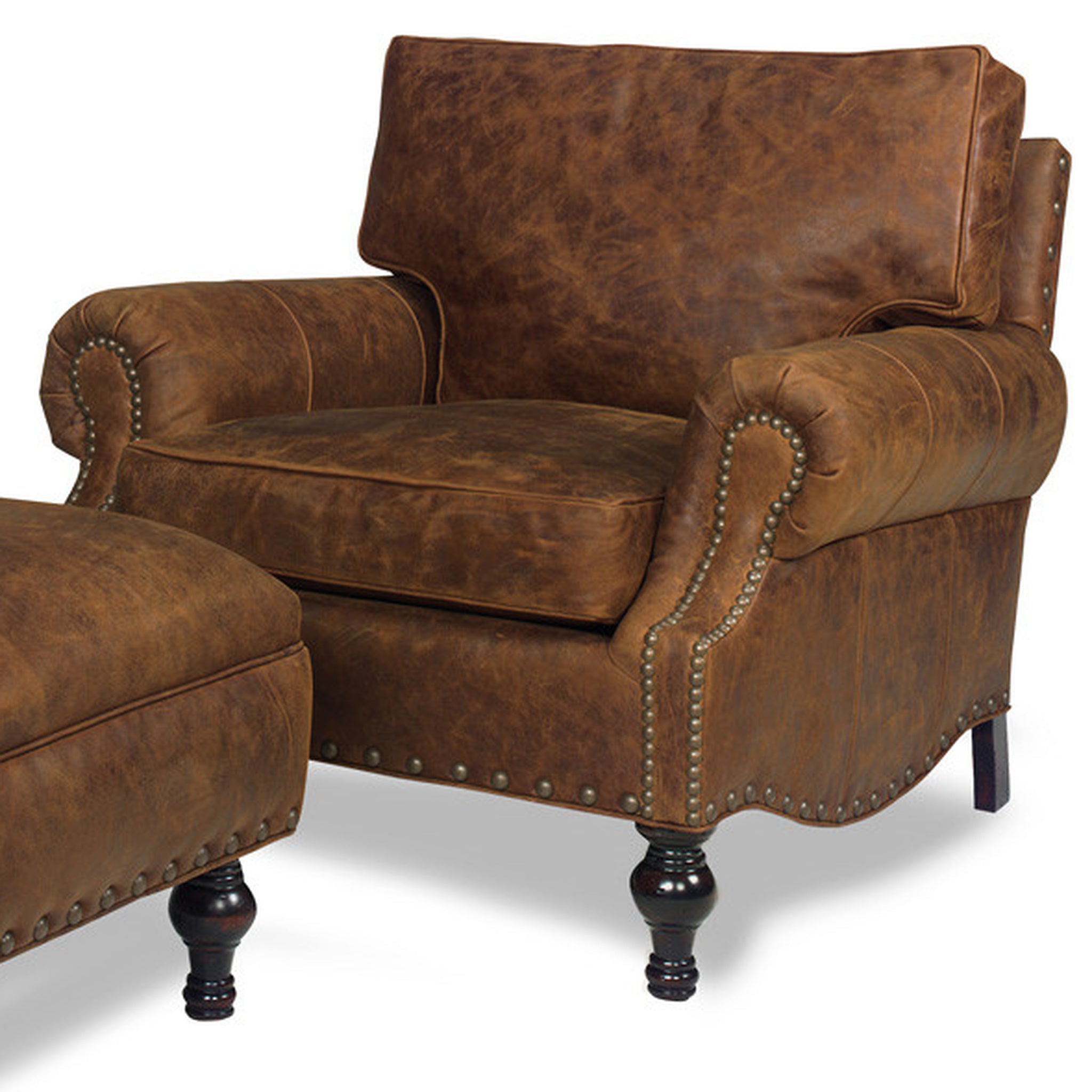 A rustic brown leather armchair with matching ottoman, featuring distressed leather texture, nailhead trim, and dark turned legs on a white background.
