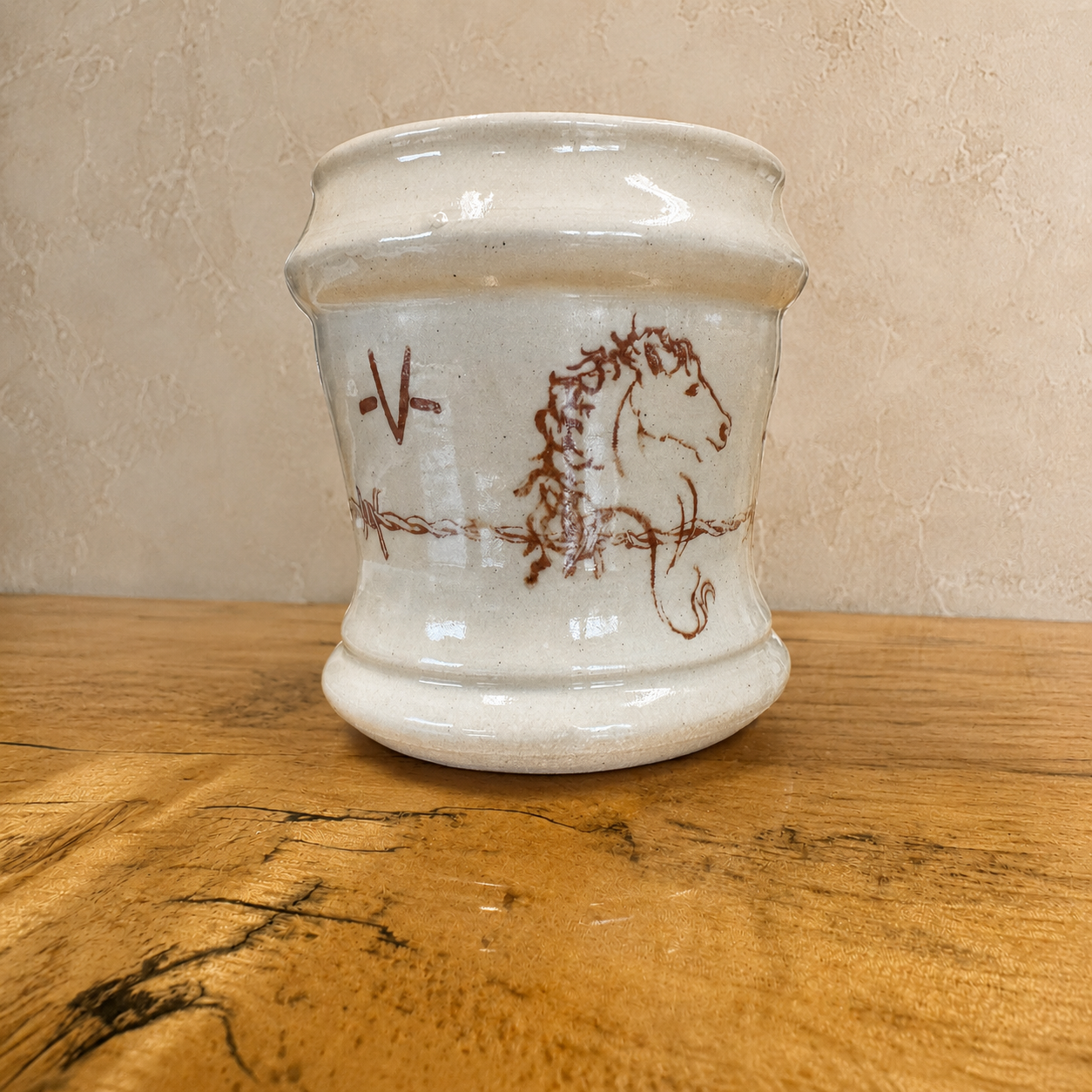 Blue Mountain Brands handmade western coffee mug featuring warm ivory base with hand drawn horse art, ranch brands, and barbed wire