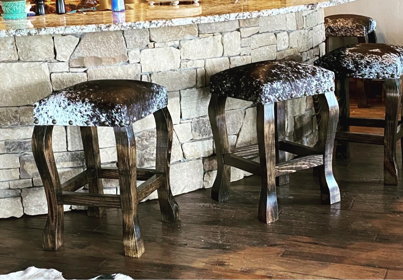 American made brown peppered cowhide western counter stools at stone kitchen counter