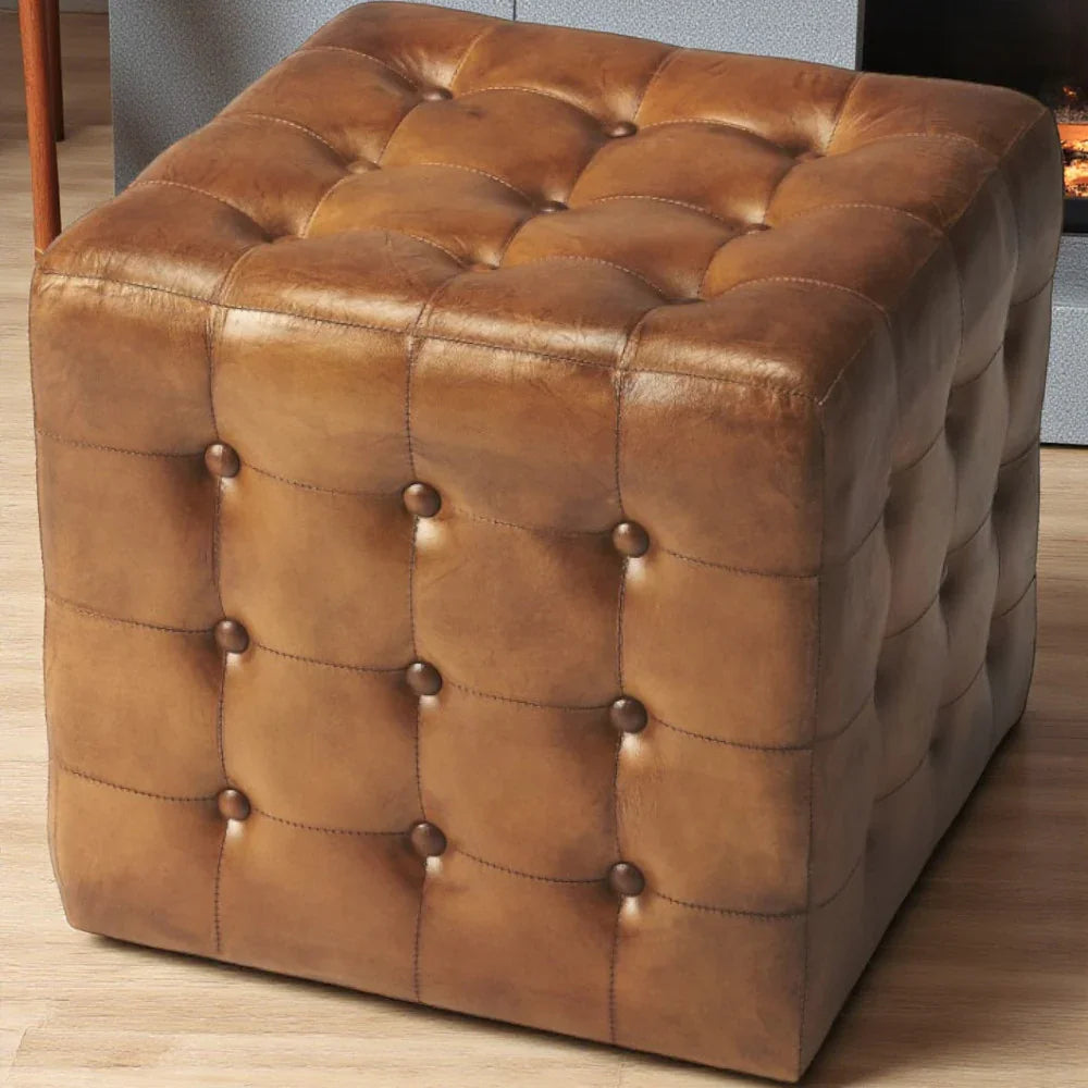 Brown leather ottoman with tufted design on a wooden floor - Your Western Decor