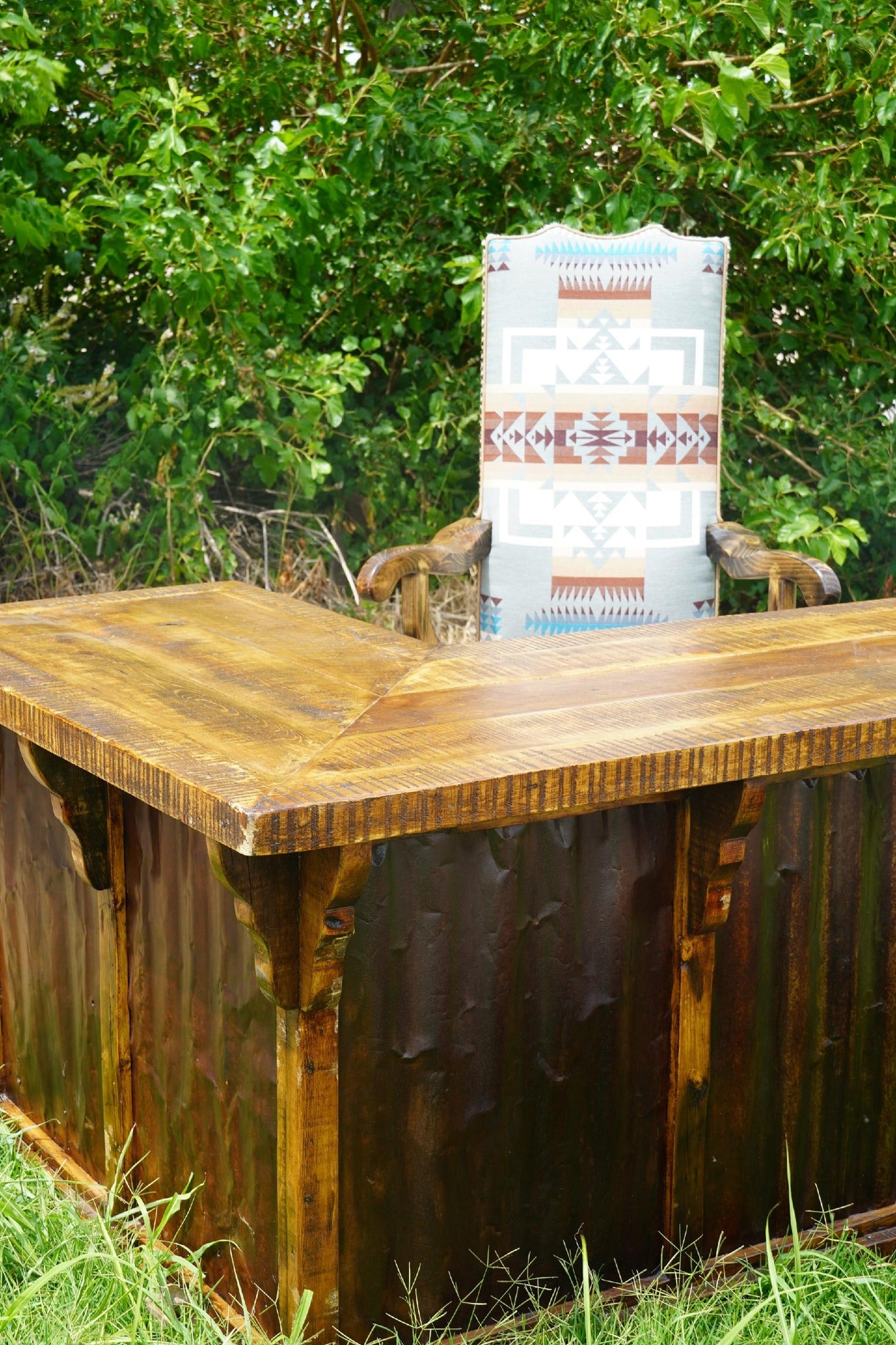 Rustic corner desk with Chief Joseph fabric upholstered Southwestern office chair outdoors