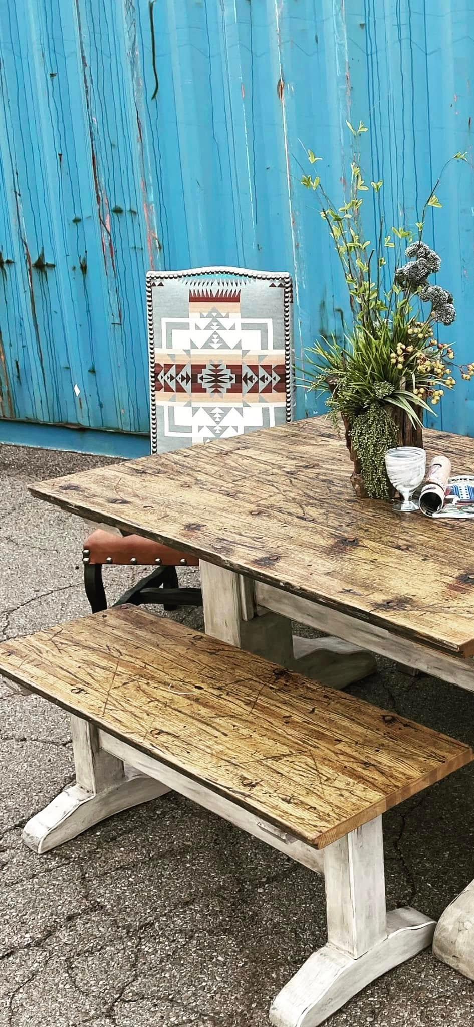 Wooden dining table with bench and chair against a blue wooden wall - YOur Western Decor