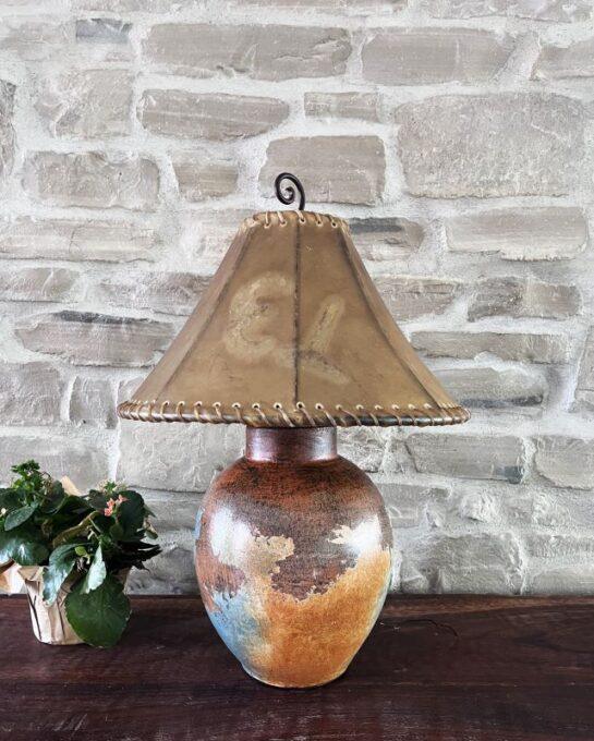 Decorative lamp with a brown lampshade against a stone wall - Your Western Decor