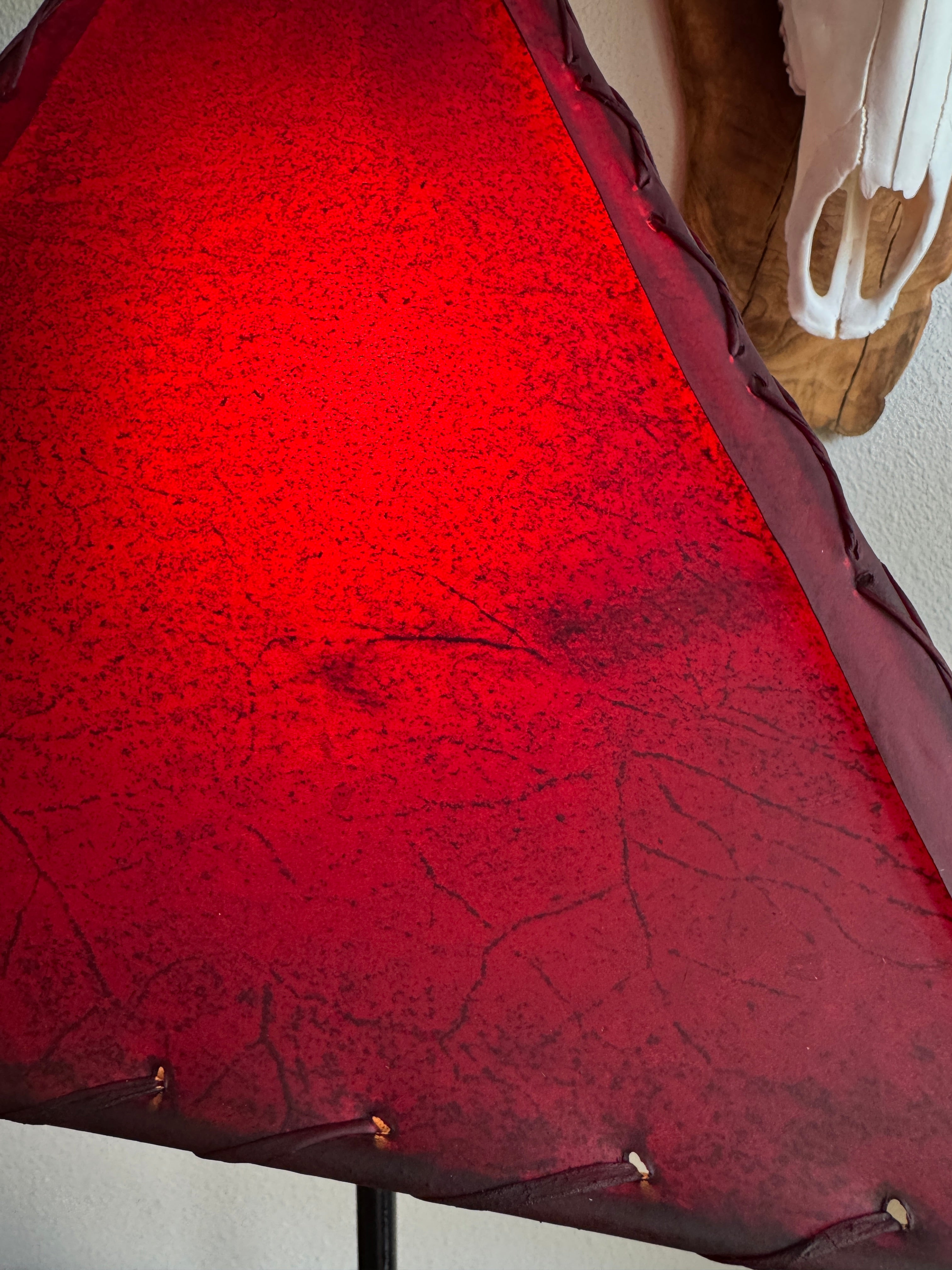 Close up of red rawhide leather on lamp shade showing veining detail and whip stitching