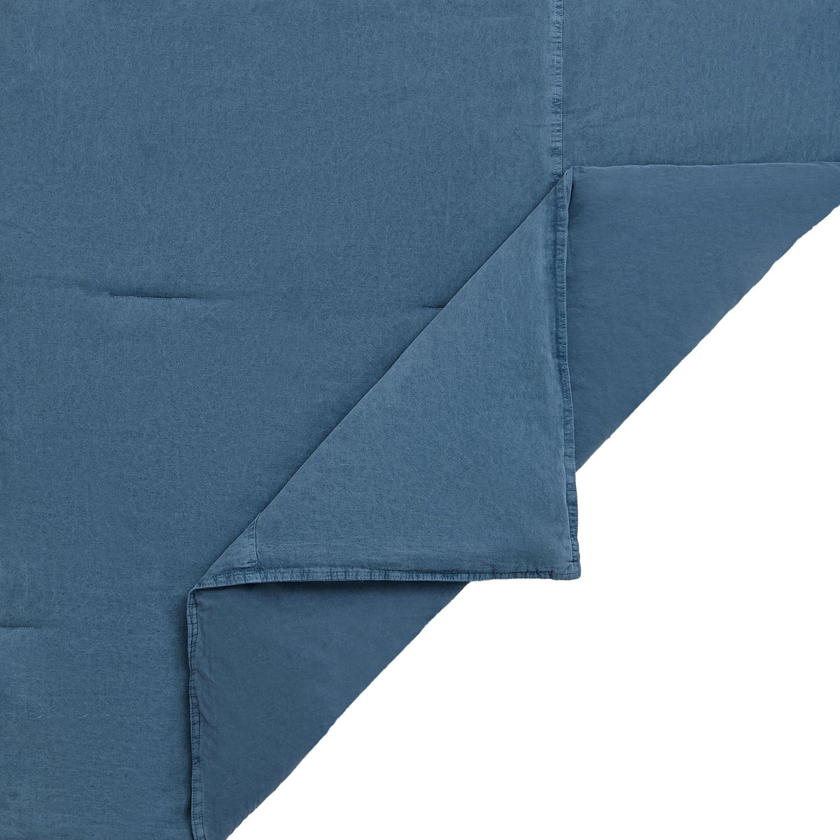 A close-up of a folded dusty blue fabric, showing the texture and hemstitching details against a plain white background.