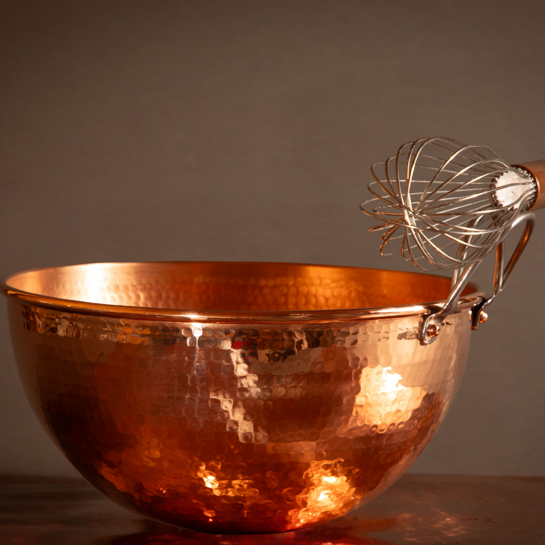 Copper mixing bowl with handle holding whisk