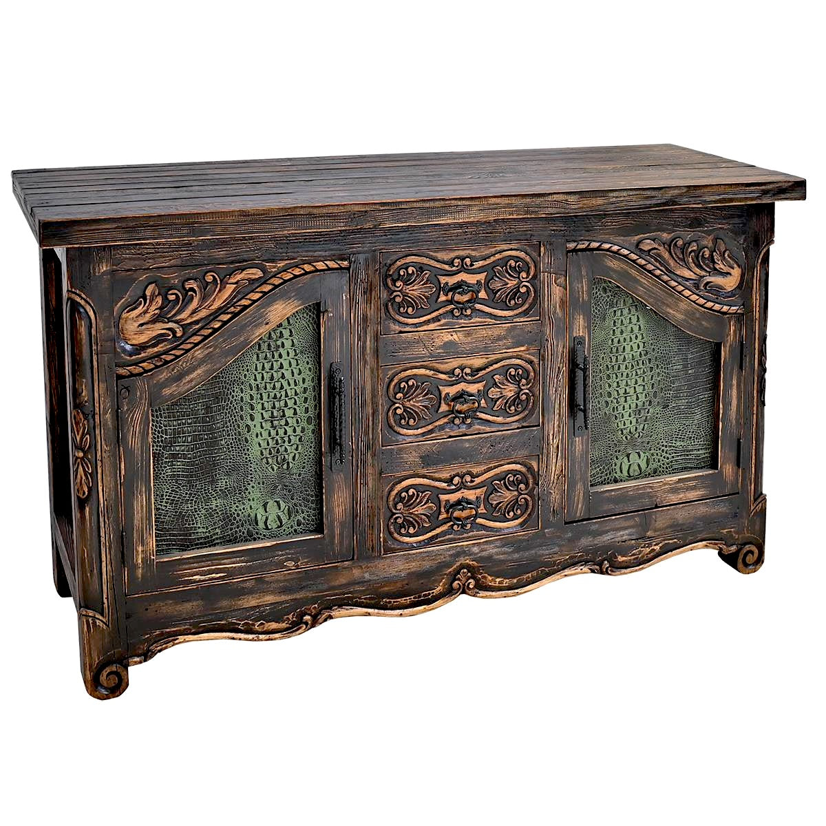A rustic dark brown wooden buffet of drawers with ornate carved details, three drawers, and textured green embossed croc leather panels, shown on a plain white background.