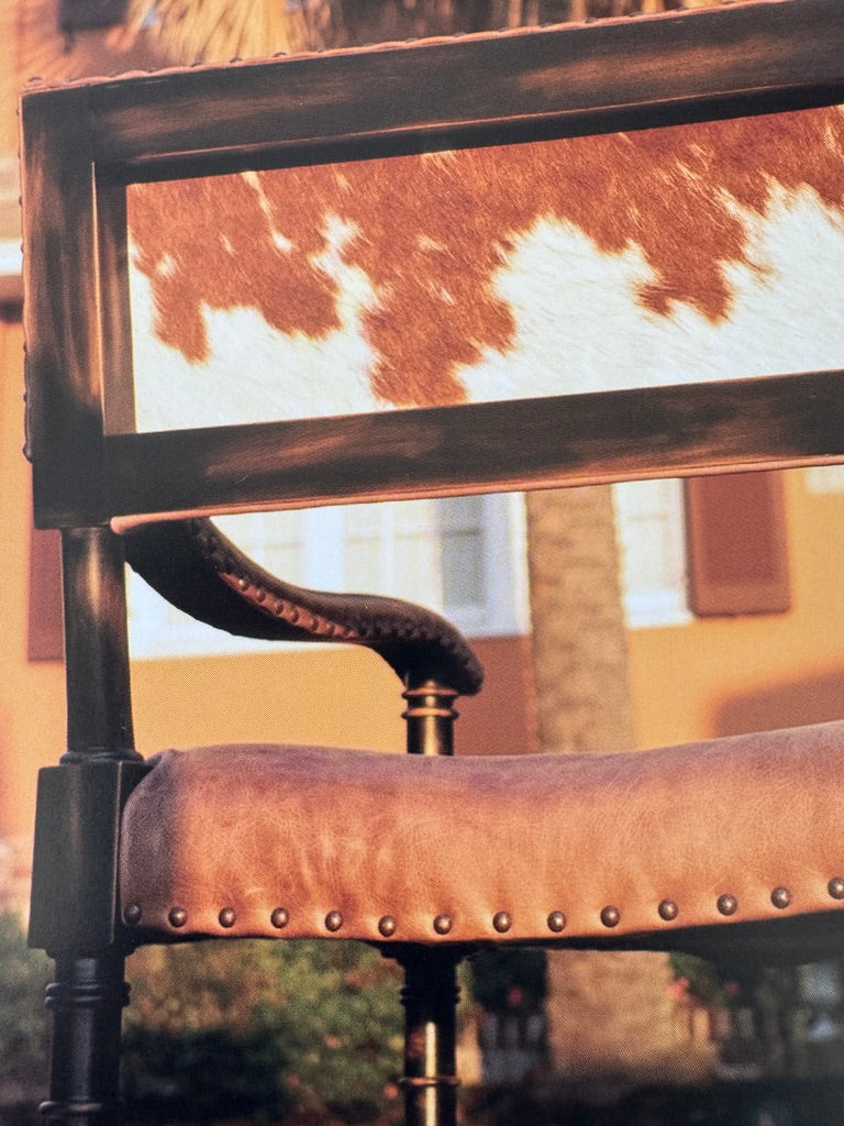 Detail of Brown white cowhide back and smooth leather exposed wood accent chair outdoors