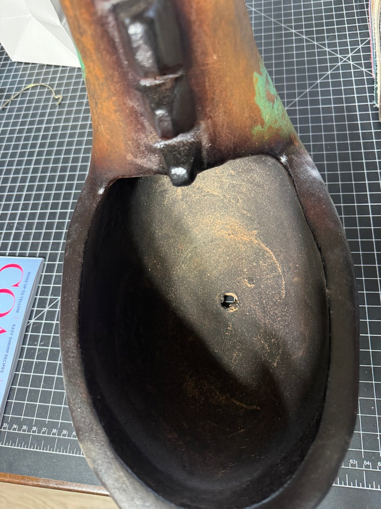 Inside clay horse planter showing drain hole