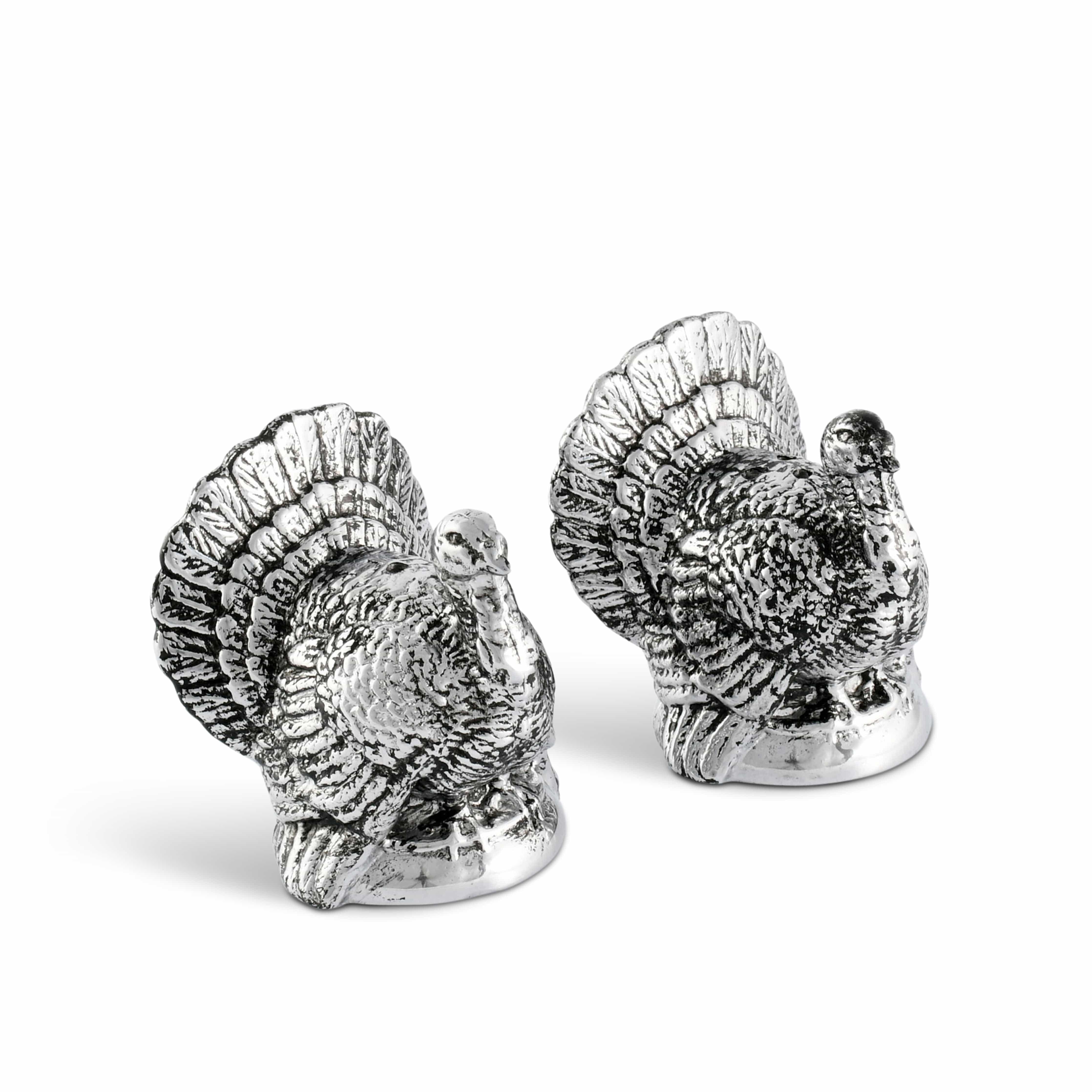 Two silver turkey figurines on a white background