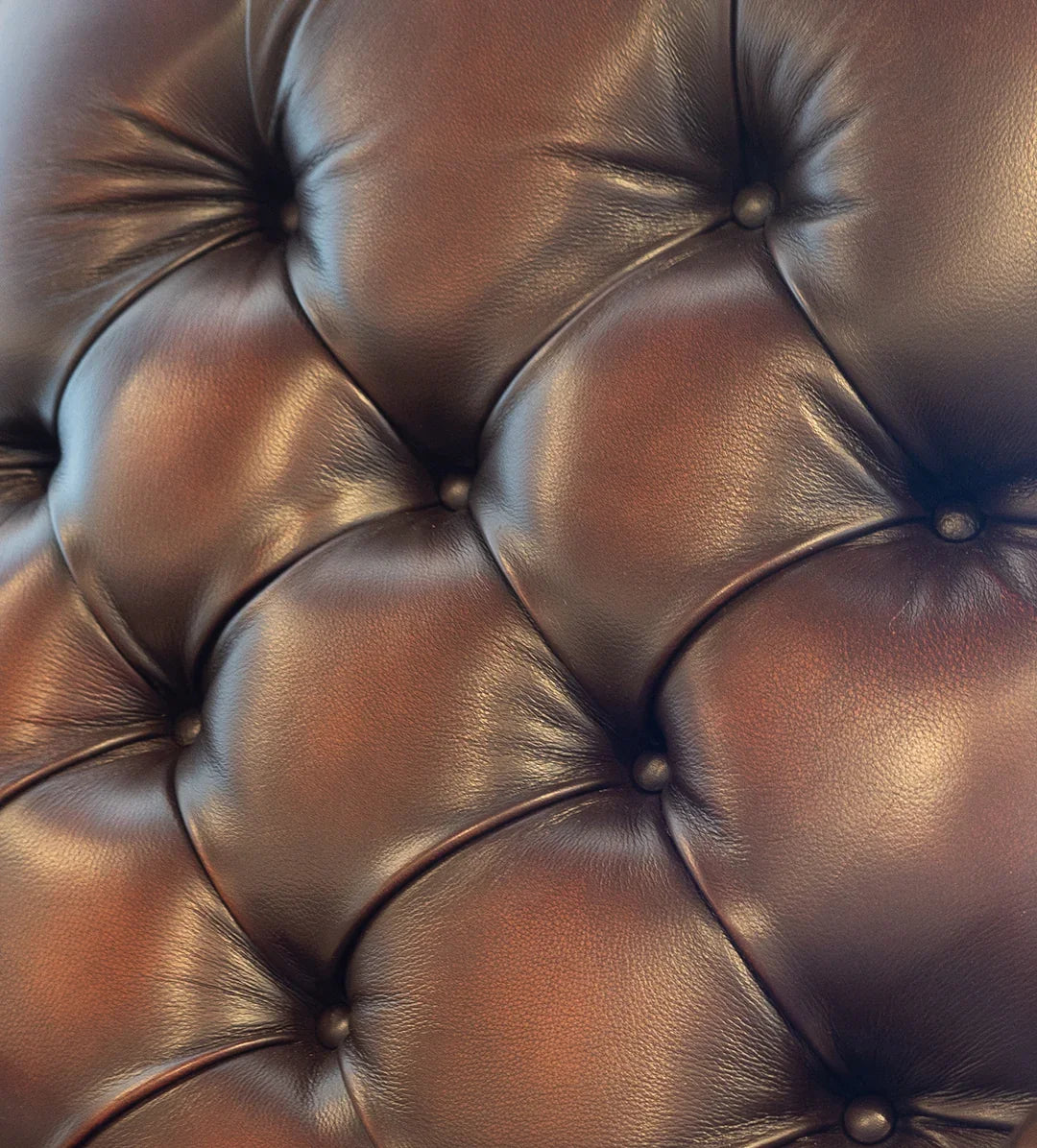 burnished leather tufted reading chair detail with nailhead trim and wood frame in western ranch office setting