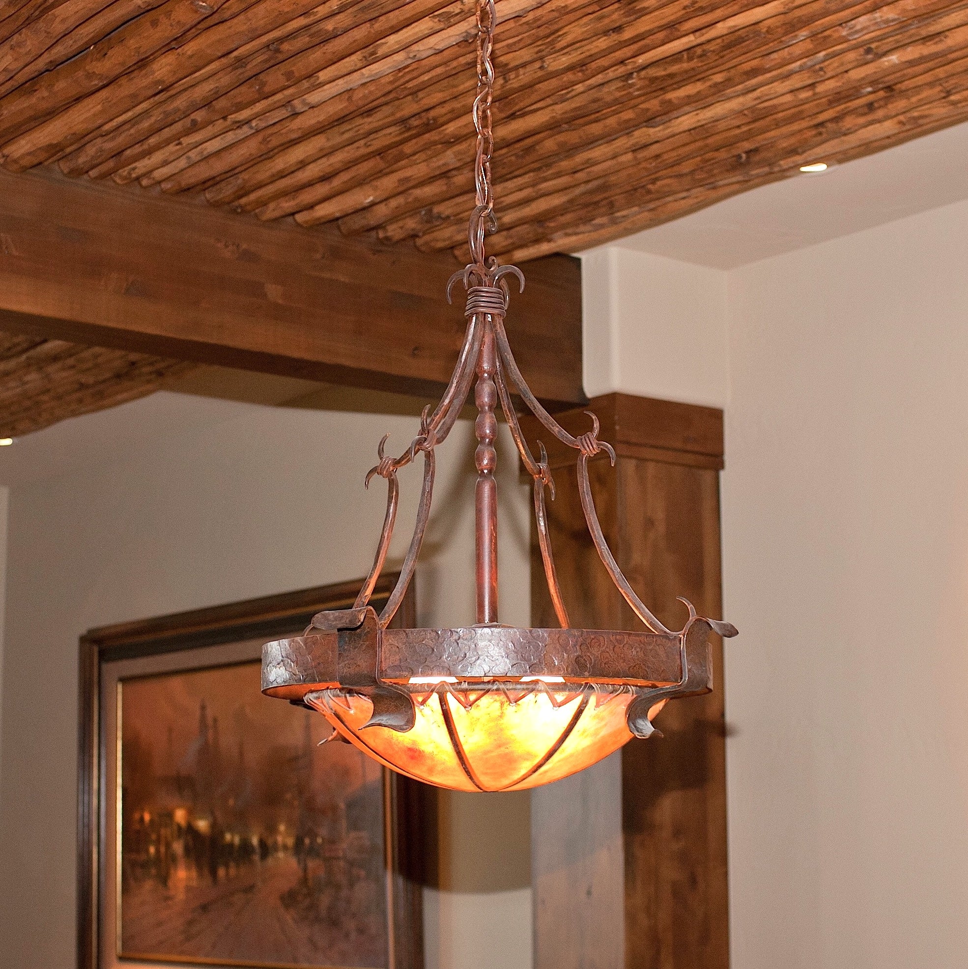 Hand-forged iron chandelier with handmade rawhide dome in western themed room
