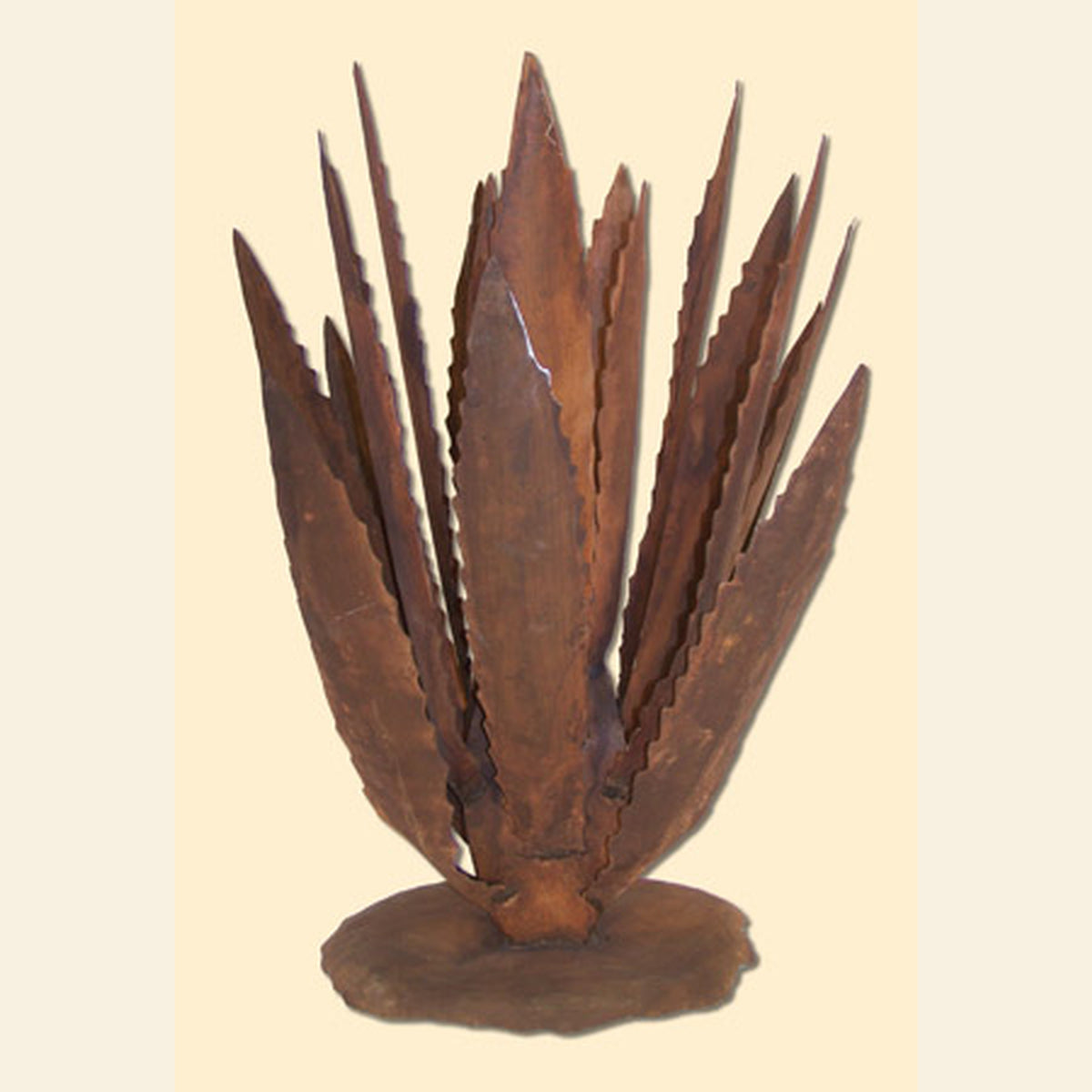 A rustic metal sculpture of a succulent or aloe plant with multiple layered, jagged leaves rising from a round base, shown against a plain beige background.