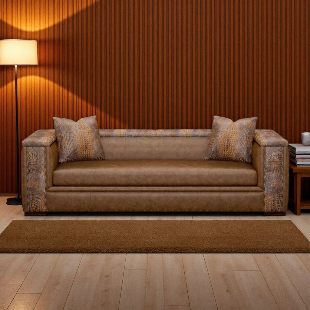 Brown sofa with patterned cushions in a room with wooden floor and wall.