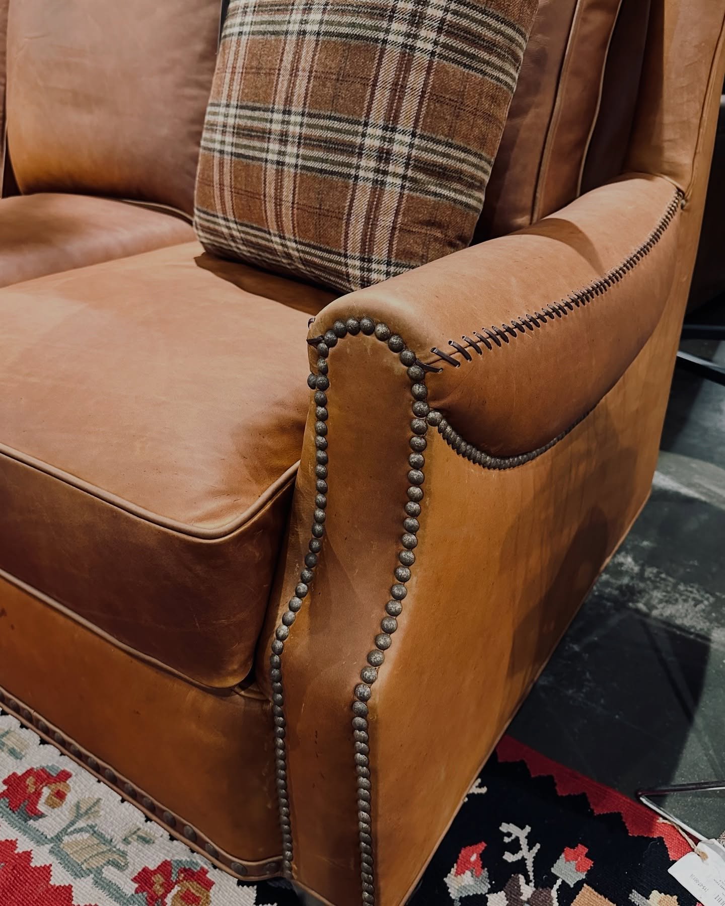 Leather sofa detail of whip-stitched sewn arm and nail trim