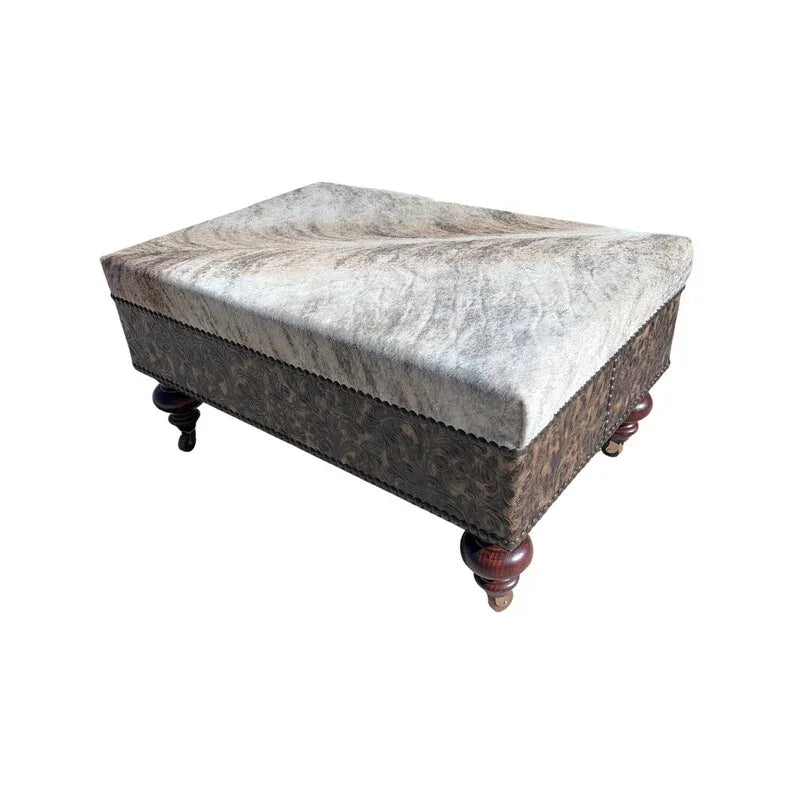 Decorative ottoman with brindle cowhide patterned top and wooden legs on a white background