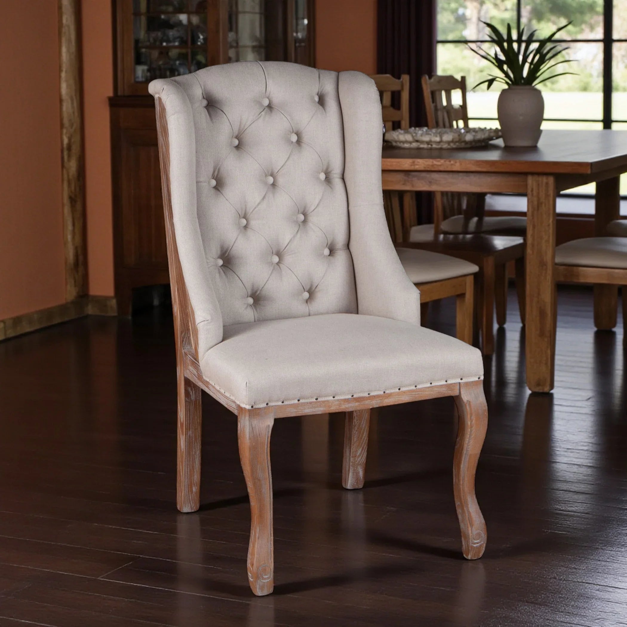 Dining chair with tufted backrest in a room with wooden floor and furniture - Your Western Decor
