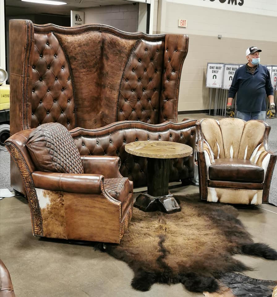 Tufted leather and cowhide bed frame with leather chairs in showroom