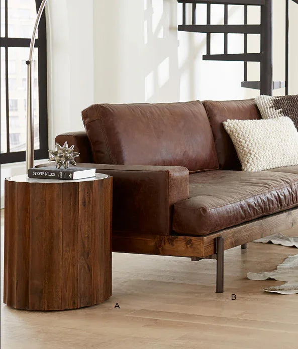 Brown leather sofa with a wooden side table in a living room setting - Your Western Decor