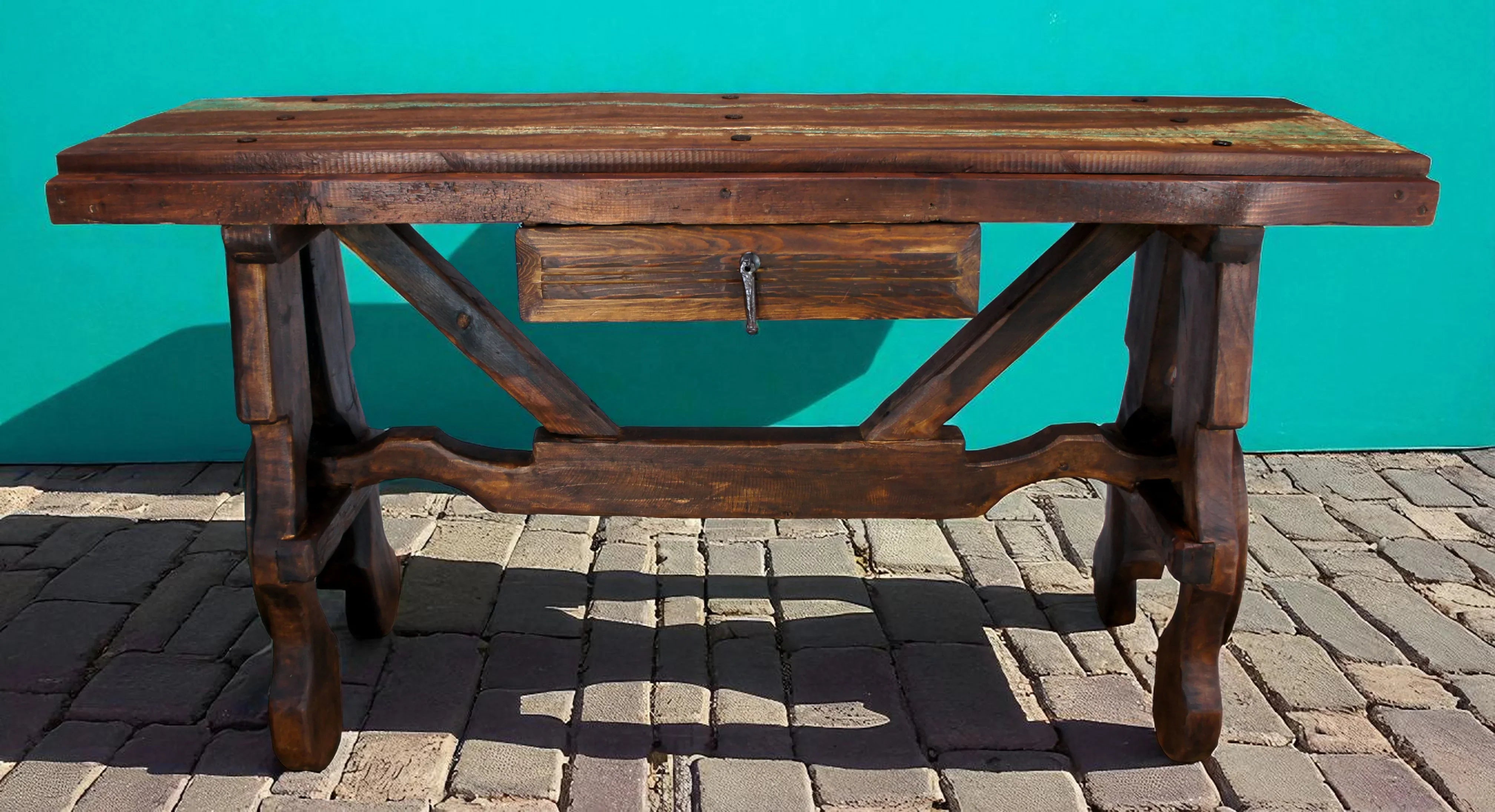 Wooden table with a drawer on a brick surface against a teal wall - Your Western Decor