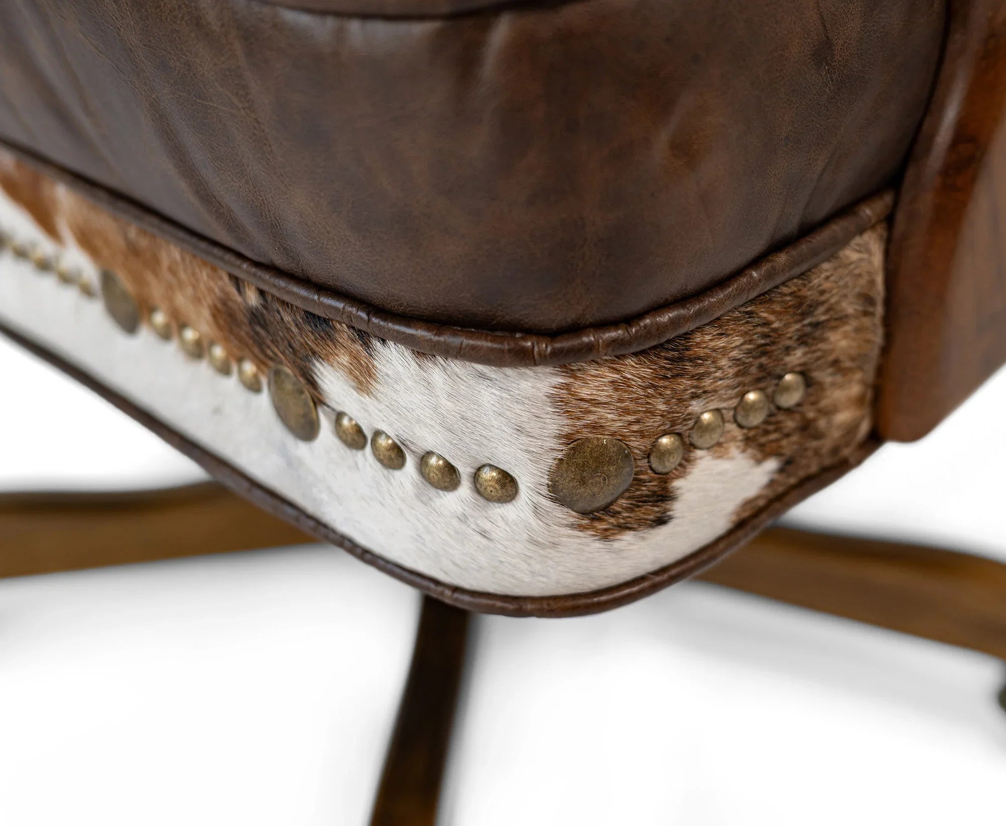 Close-up of a brown leather chair with cowhide trim and gold studs on a white background - Your Western Decor
