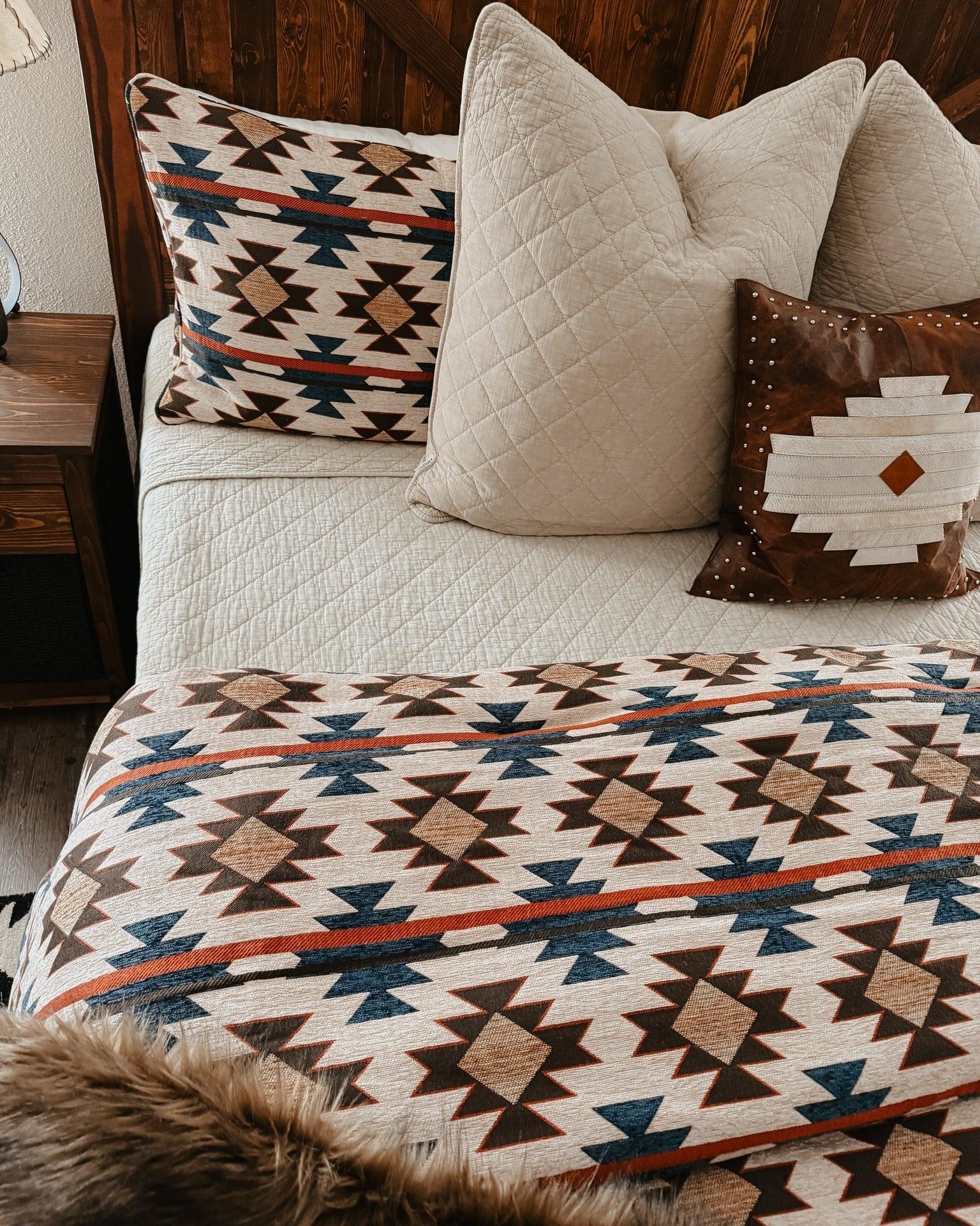 Bed with patterned quilt and pillows in a cozy bedroom setting - Your Western Decor