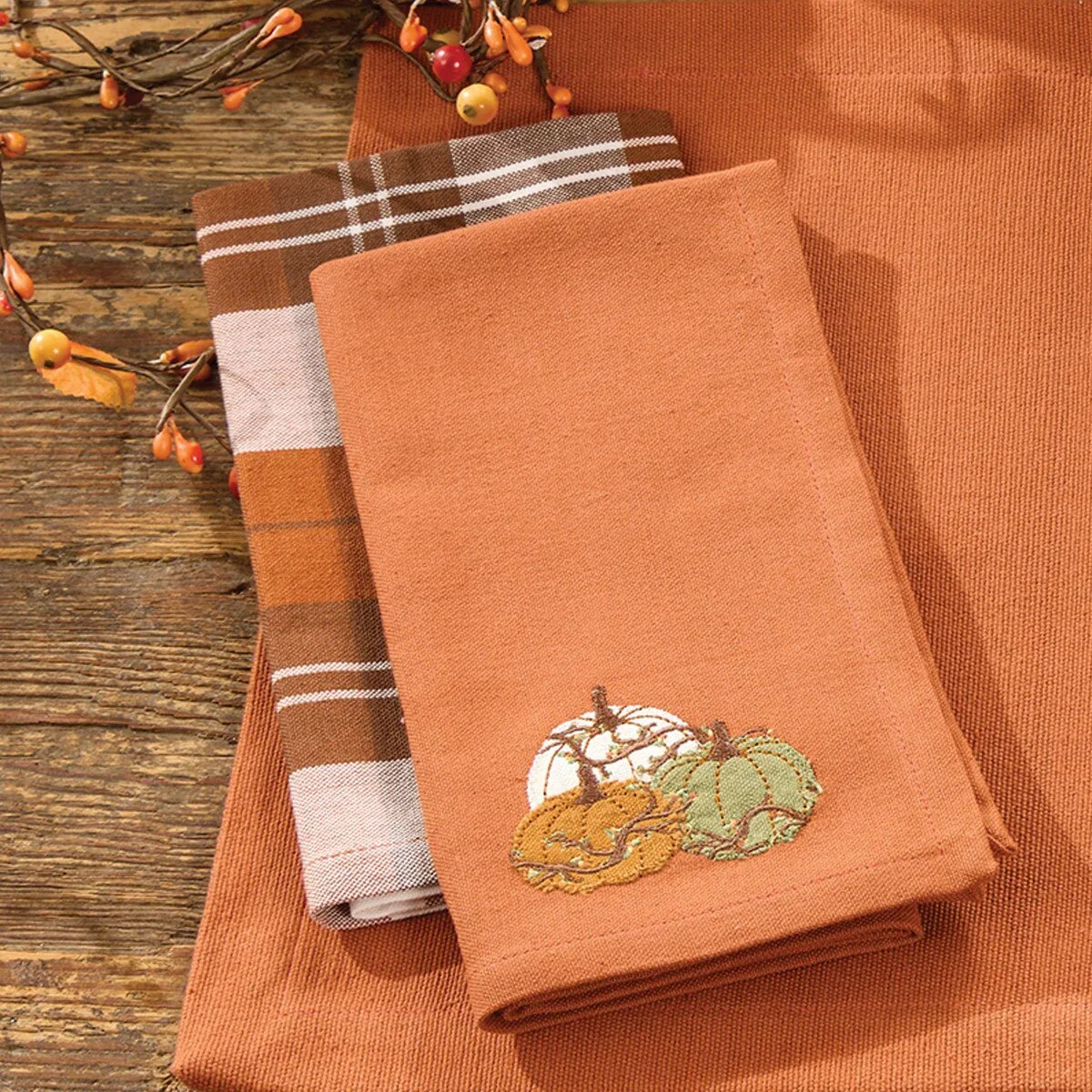 Set of orange towels with embroidered pumpkins on a wooden surface - Your Western Decor