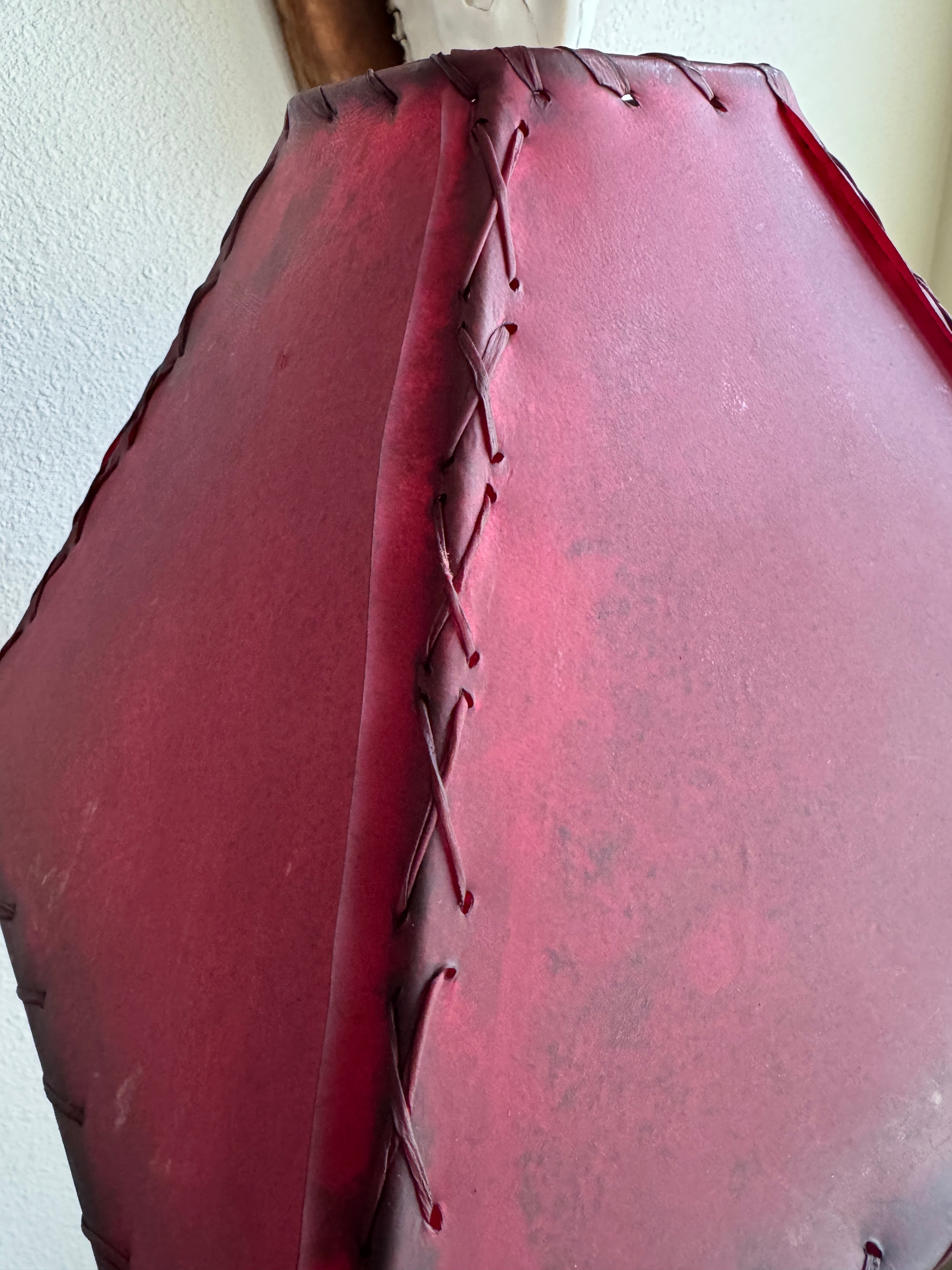 Stitching detail on red rawhide leather lamp shade