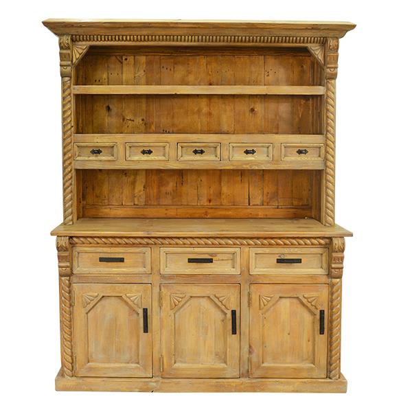 A rustic pine hutch cabinet with a warm yellow-tan finish, featuring three open shelves, five small drawer fronts with dark metal pulls, and three lower cabinet doors with carved panel details and black handles.
