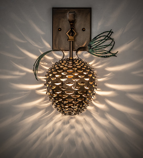 rustic pinecone wall sconce with antique copper finish casting warm ambient light on wall in lodge style home