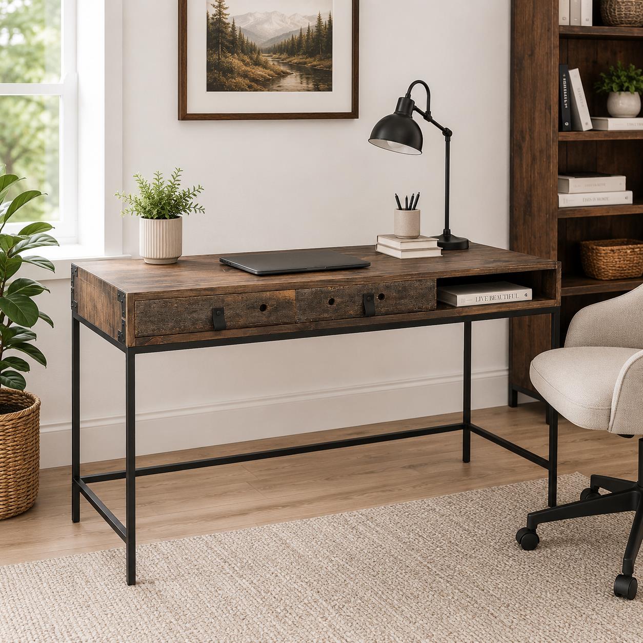 A rustic wooden writing desk with a black metal frame, styled in a home office setting with a lamp, laptop, books, and a chair.