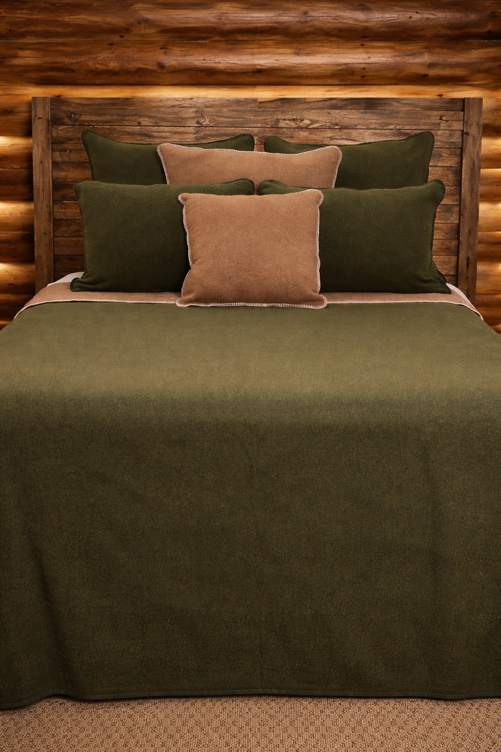 Bed with green and brown bedding against a wooden headboard - Your Western Decor