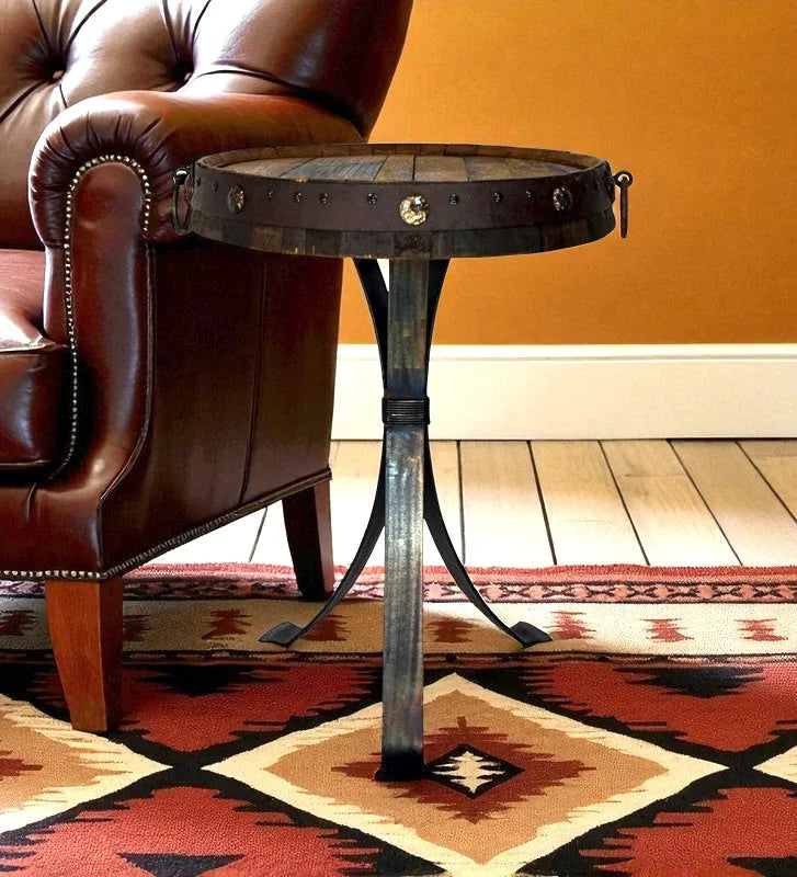 Small round metal table with decorative legs next to a brown leather chair on a patterned rug. Your Western Decor