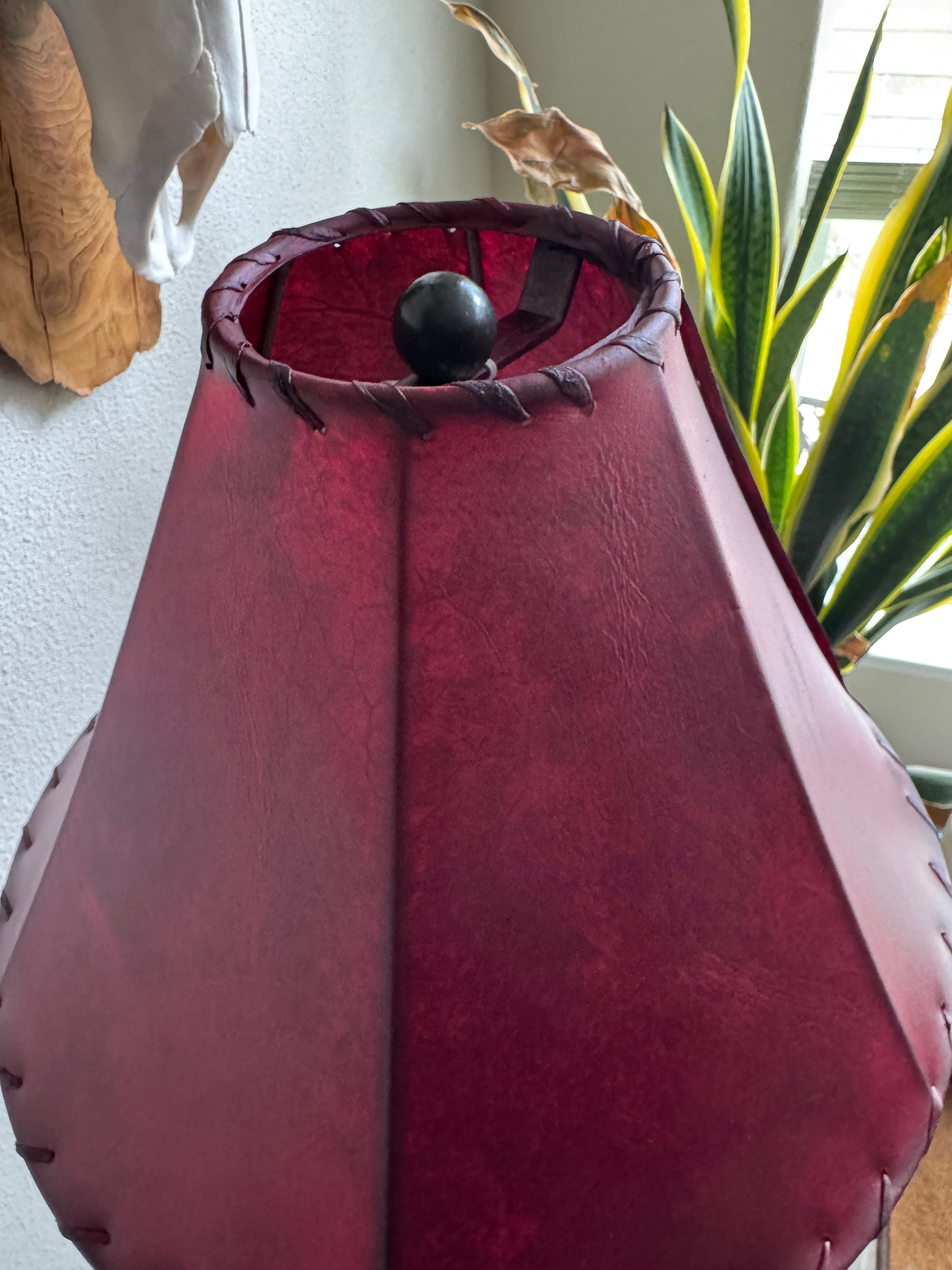 Red rawhide lamp shade showing detail of top and whip stitching