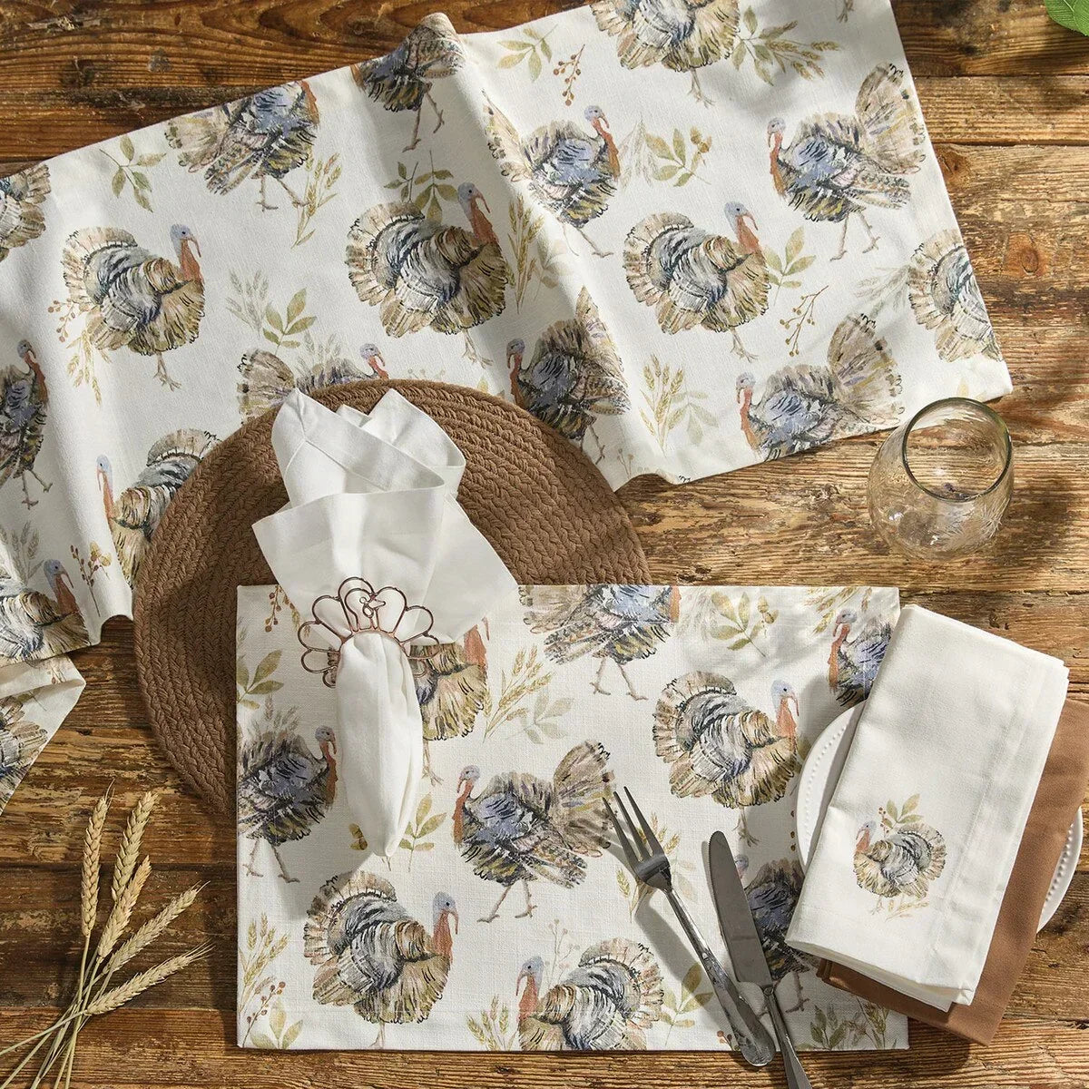Table setting with turkey-patterned placemats, napkins, and cutlery on a wooden table - Your Western Decor