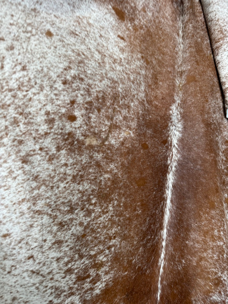 Close up of peppered brown and white cowhide rug