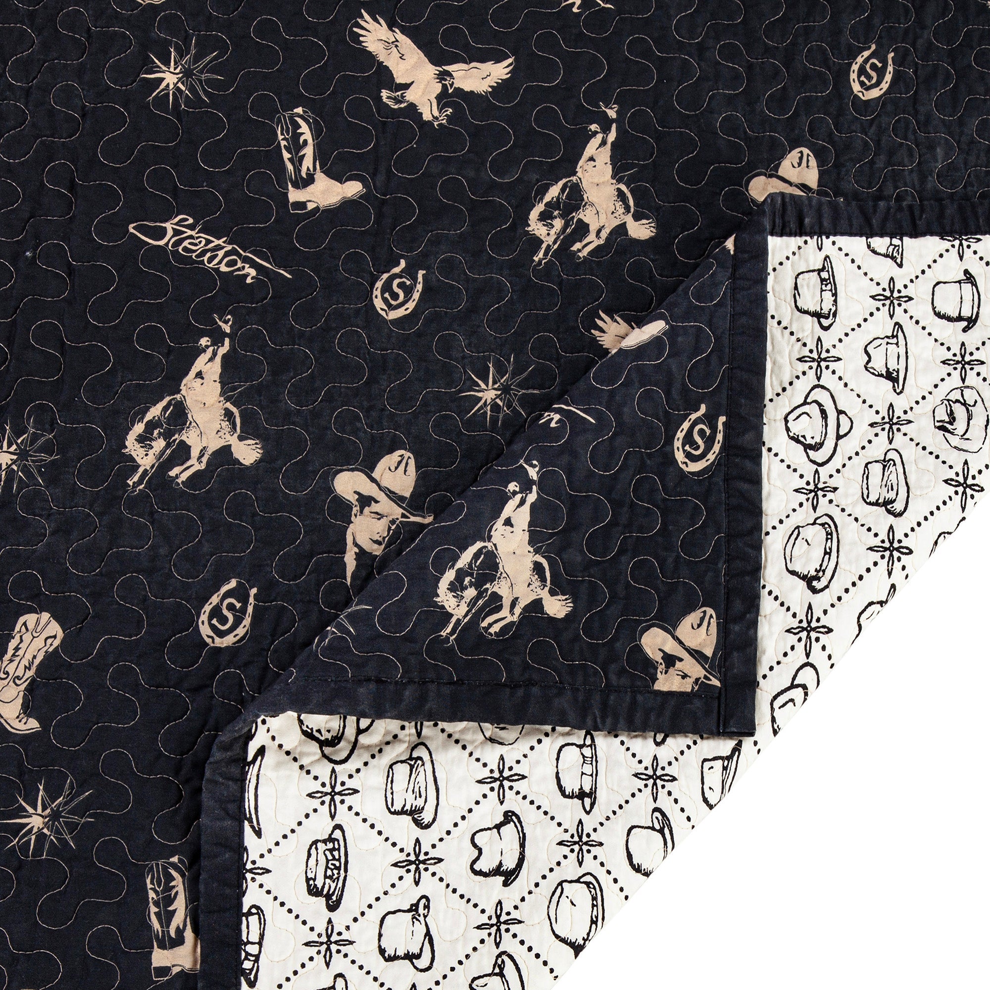 Black western quilt showing white western patterned reverse